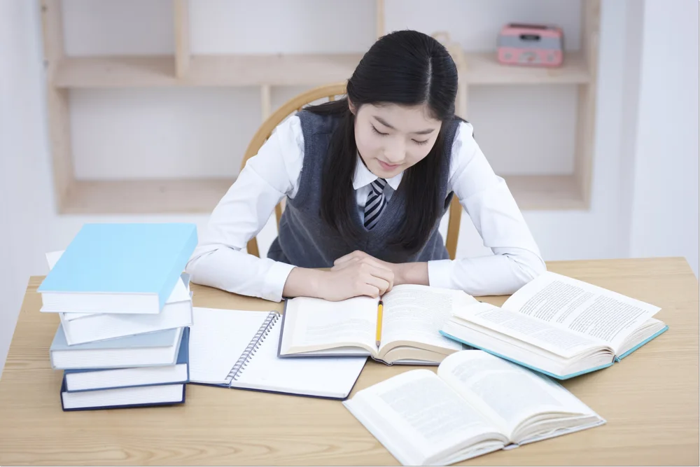 교재를 보며 필기하는 학생