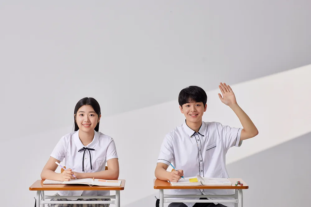 교실에서 질문하며 손을 드는 학생