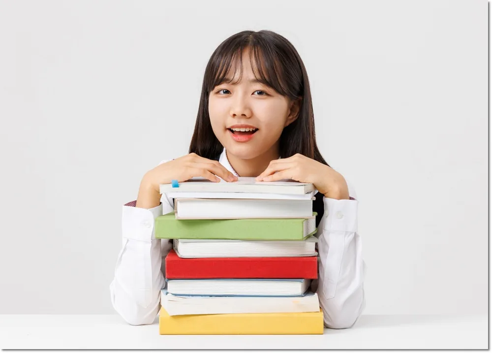 여러 권의 책을 앞에 둔 학생