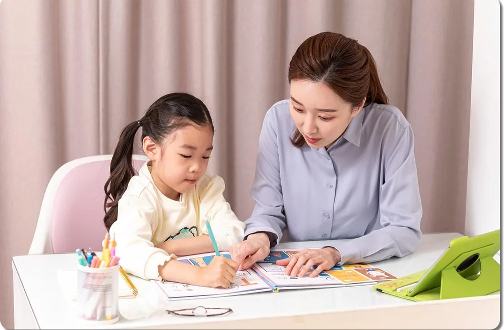 아이와 보호자가 교재를 함께 읽는 모습