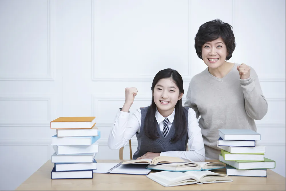 교재 앞에서 손을 드는 학생과 지도자