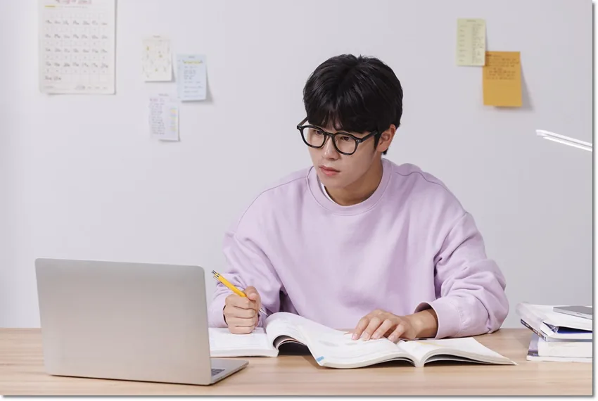 책상에서 필기하는 학생